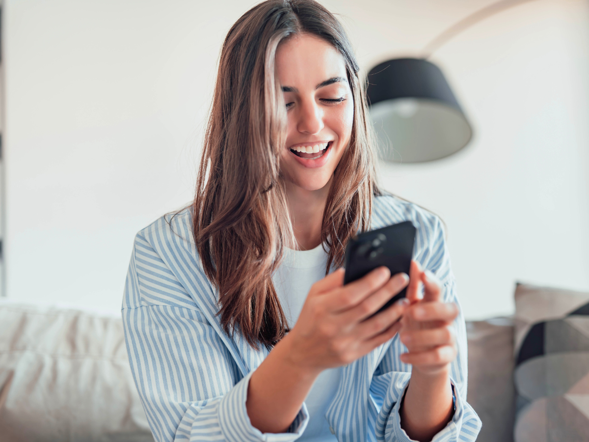 Γυναίκα που ενημερώνεται για τη σύνδεση και τις υπηρεσίες ενέργειας μέσω κινητού και υπολογιστή.