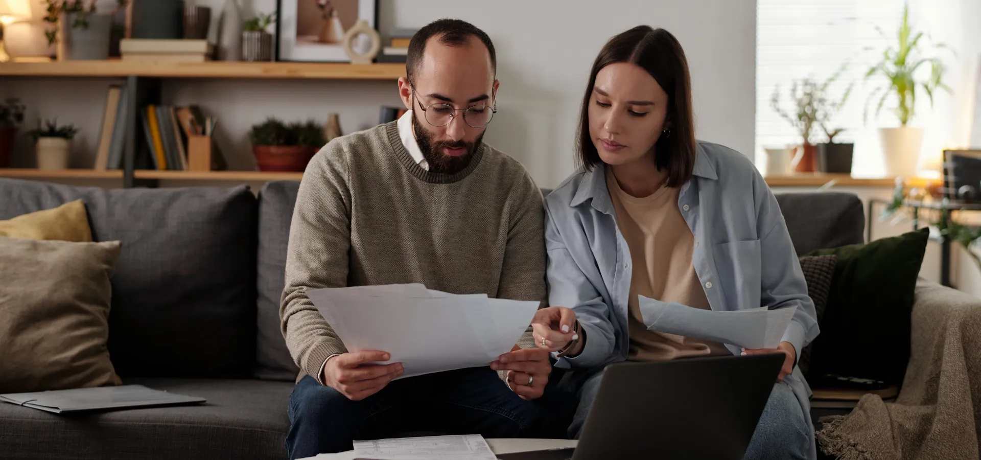 ζευγάρι που κάθεται και αναλυεί τον λογαριασμό του στο σπίτι του